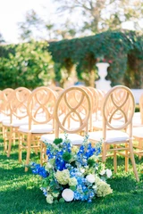 Blue, green, and white floral meadow placed at the end of the aisle to decorate a seating area at a wedding ceremony. 