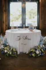 Sweetheart table decorated for a wedding celebration with floral arrangements on each side.