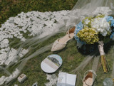 A detailed shot of a brides wedding veil with the bridal bouquet and shoes laying on top