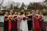 Bridal party walking while holding red and white flowers