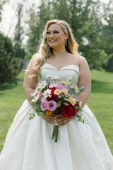 A bride holding a multi-color wildflower bridal bouquet.