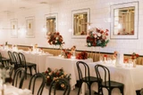 A photo of tables decorated at an intimate indoors wedding reception.