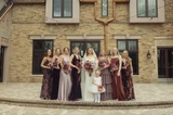 Bride and her bridesmaids in purple dresses holding purple flowers