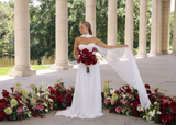  Bride in a modern white gown holding a red rose and calla lily bridal bouquet surrounded by red and green florals