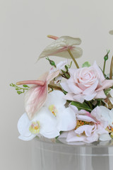 Close-up of a wedding floral arrangement featuring blush anthuriums, white orchids, pale pink roses, and soft blush blooms.