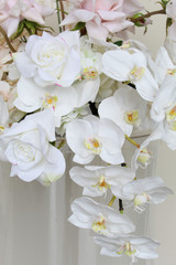 Close-up of cascading white orchids and ivory roses in a romantic wedding floral arrangement.
