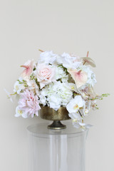 Grand centerpiece featuring white hydrangeas, white roses, blush roses, blush anthuriums, and cascading orchids in a gold compote vase.
