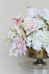 Grand centerpiece featuring white hydrangeas, white roses, blush roses, blush anthuriums, and cascading orchids in a gold compote vase.