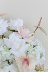 Close-up of a grand centerpiece featuring white hydrangeas, white roses, blush roses, blush anthuriums, and cascading orchids in a gold compote vase.