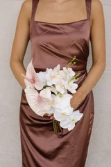 Bridesmaid bouquet featuring blush anthuriums, white phalaenopsis orchids, and delicate blush orchid blooms.