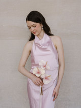 Bridesmaid holding the Blush Anthurium Petite Bouquet featuring three blush pink anthuriums with flowing ivory ribbon against a blush satin dress.