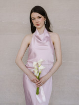 Portrait of a bridesmaid holding the White Calla Lily Petite Bouquet, featuring four white calla lilies and a flowing ivory ribbon.