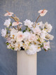 Garden-style floral arrangement featuring blush anthuriums, white phalaenopsis orchids, blush roses, and ivory blooms.