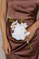 Bridesmaid holding a small floral arrangement with white rose and peach orchids