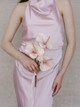 Bridesmaid holding the Blush Anthurium Petite Bouquet featuring three blush pink anthuriums with flowing ivory ribbon against a blush satin dress.