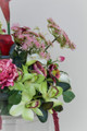 Floral Meadow featuring deep burgundy calla lilies, white calla lilies, blush peonies, pale green hydrangeas, green cymbidium orchids, burgundy roses, white anthuriums, cascading burgundy amaranthus, and airy pink accent blooms.