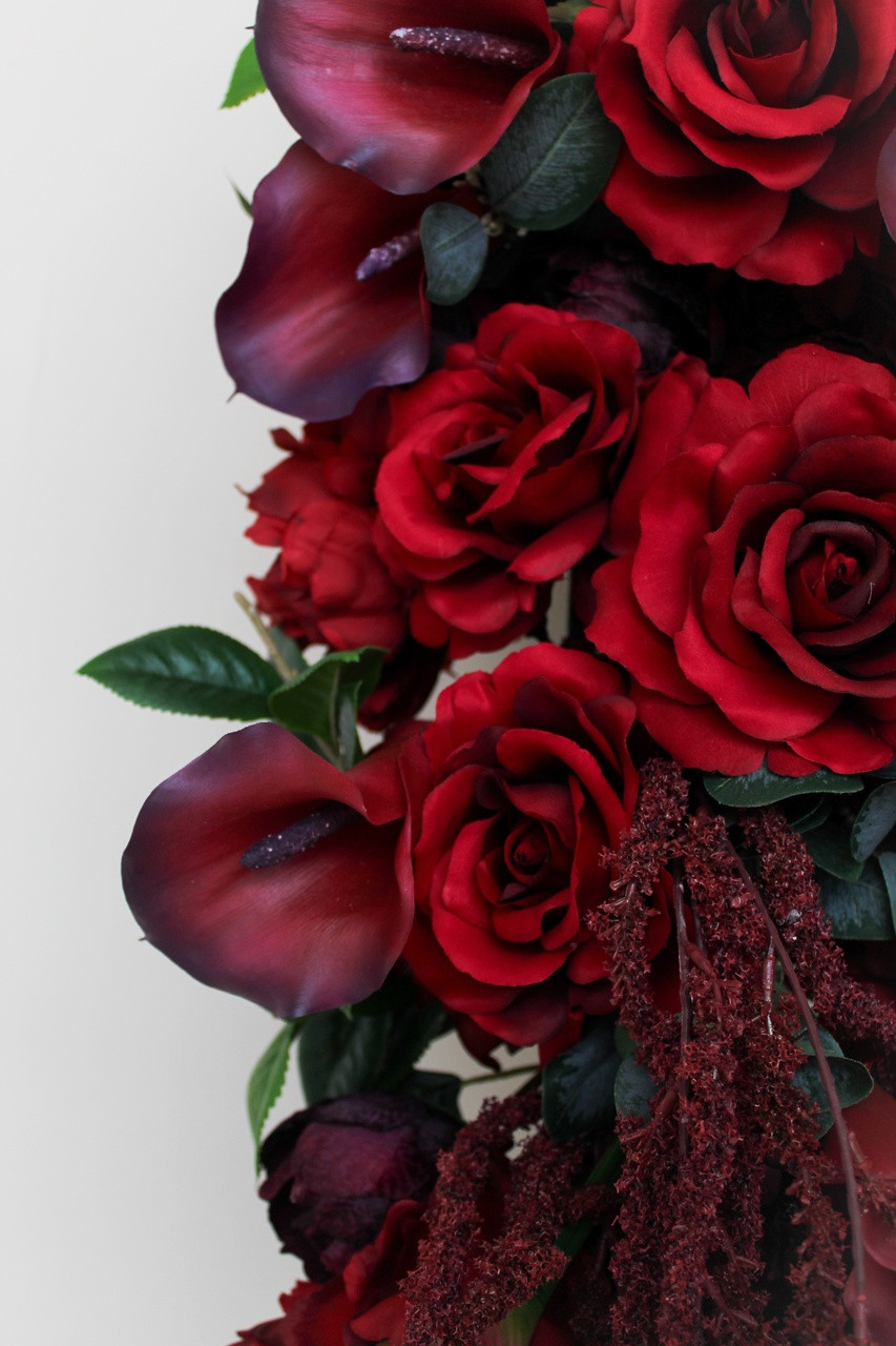 Luxurious burgundy floral runner featuring rich red roses, deep burgundy peonies, burgundy calla lilies, cascading burgundy amaranthus, and lush greenery. This premium silk floral table runner creates a dramatic, romantic statement for wedding reception tables, sweetheart tables, and ceremony décor