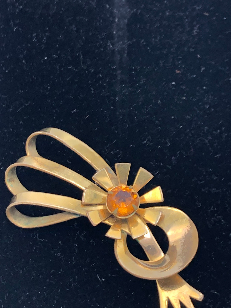 Gold tone swirl with orange stone brooch