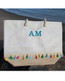 Straw beach tote with pom poms