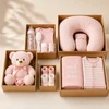 Unboxed five-tier baby girl gift tower with pink plush bear, clothes, and blankets for a baby shower gift.