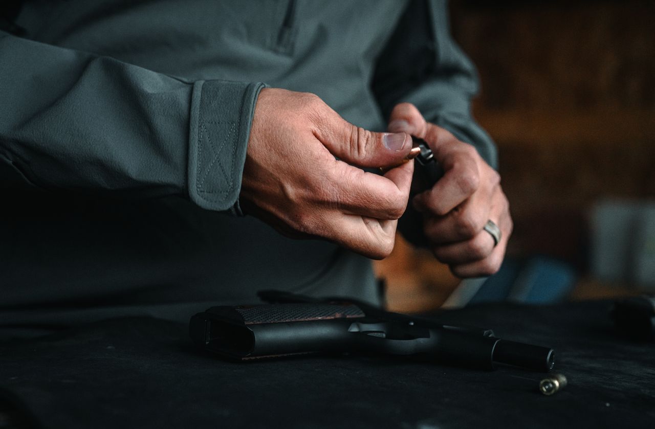 A stainless Tisas 1911A1 TC held in low light