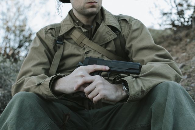 Tisas US Army, WWII kit, seated with the pistol on the knee