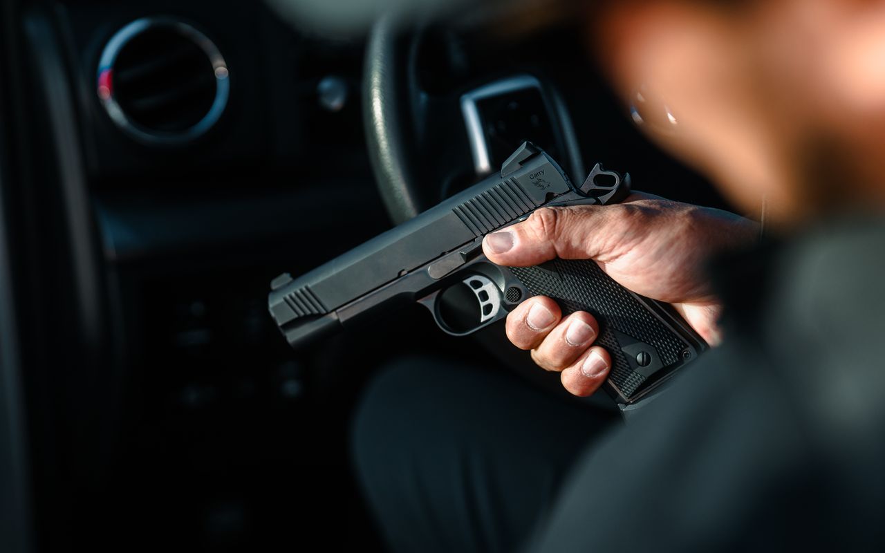 A Tisas 1911 Carry held in the hand inside a vehicle