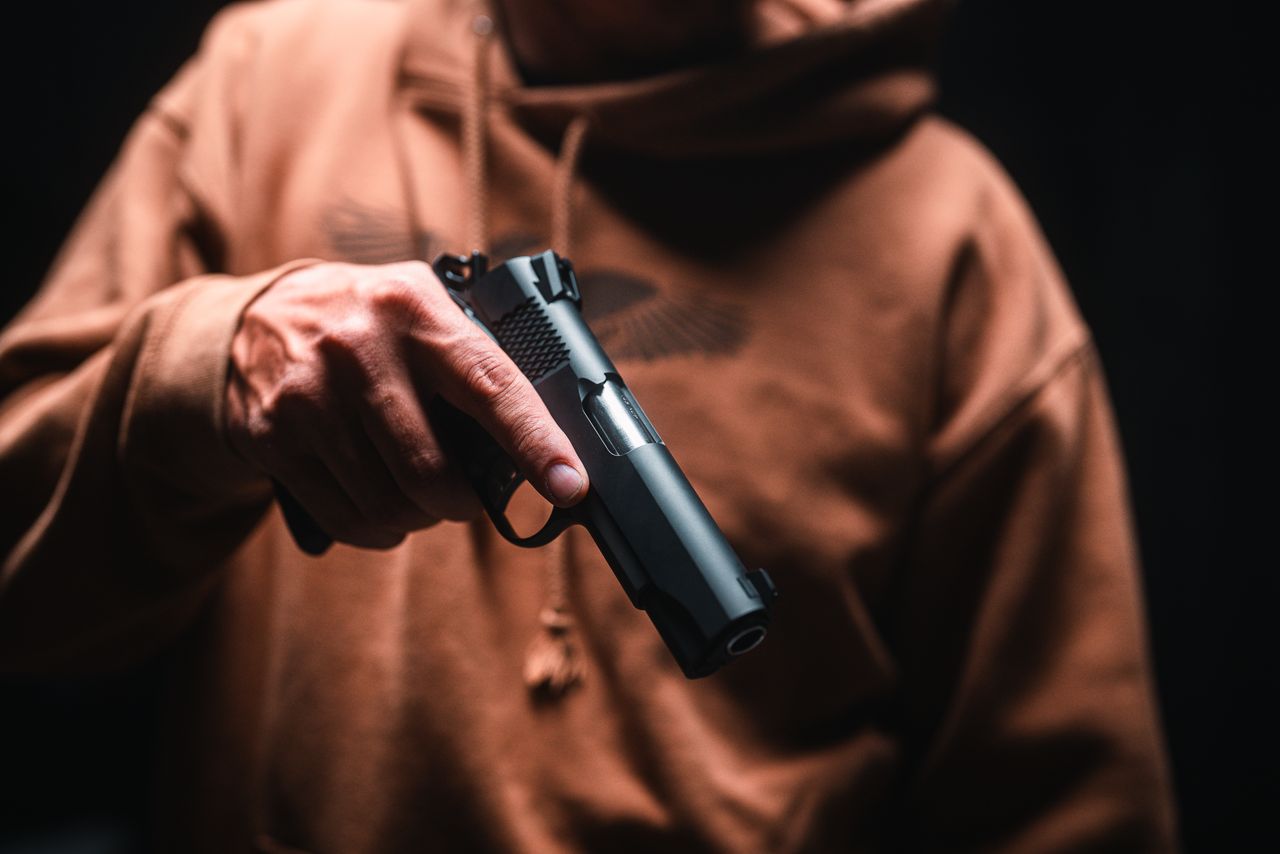A Tisas 1911 Carry Stingray held out against a dark background