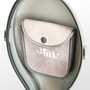 Interior view of a built-in accessory pouch with a suede-like finish and a snap button closure. The pouch is branded with the "JML®" logo and is neatly integrated into the lid of the case for convenient storage of small items such as rosin, strings, or a tuner.