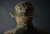Close shot of a trooper back head wearing a  Carcajou's Sniper boonie hat multicam mesh and nething , on fornt of gradient dark background.