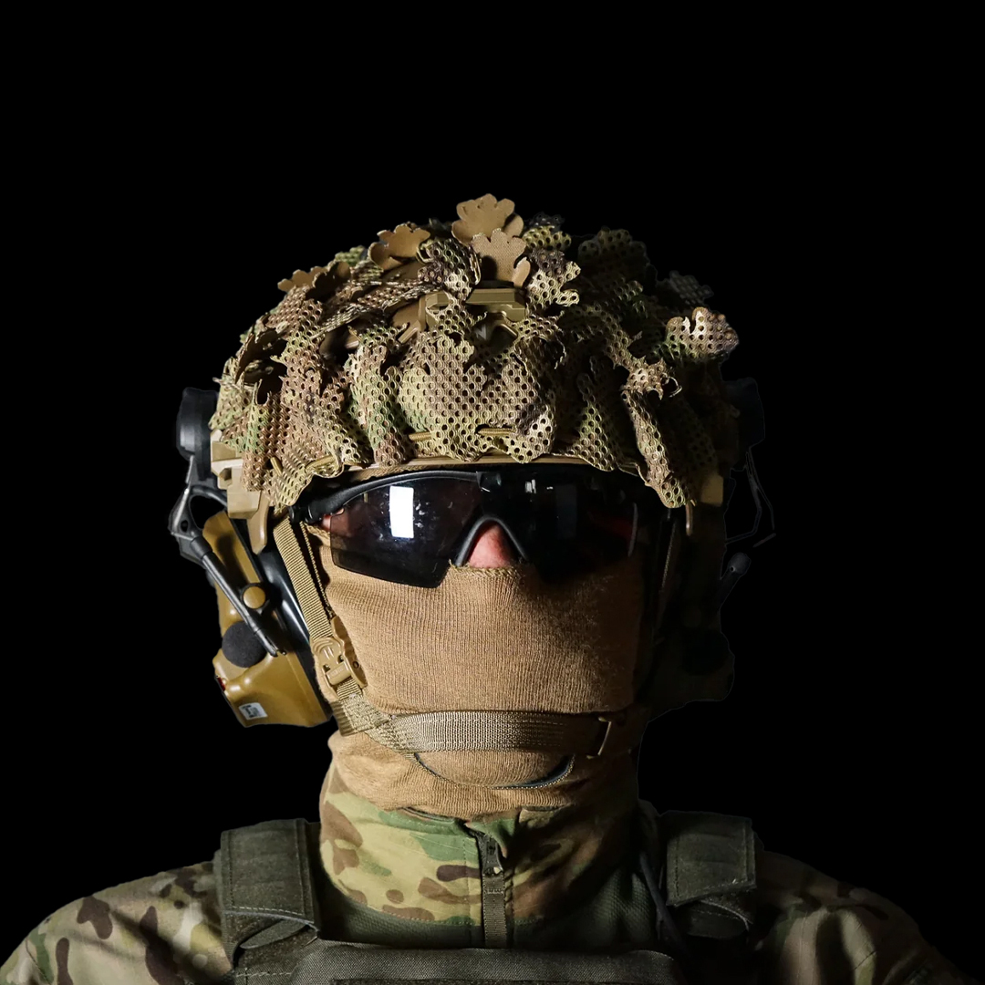 Front view of operator wearing Carcajou Tactical high cut helmet with Multicam scrim cover, headset, and tactical gear, available at Hudson Supplies Corp USA