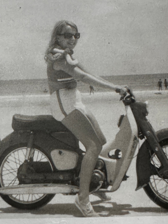 Woman on Motorcycle with a Snake Around Her Neck at the Beach - 1960s - Orphaned Photo