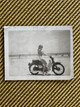 Woman on Motorcycle with a Snake Around Her Neck at the Beach - 1960s - Orphaned Photo