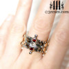 silver crown ring with faceted garnets on middle finger