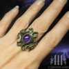 empress vampire brass ring with amethyst cabochon on middle finger

