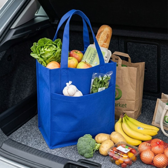 A blue shopping bag filled with lettuce, apples, bread, vegetables, and other groceries in a car boot.