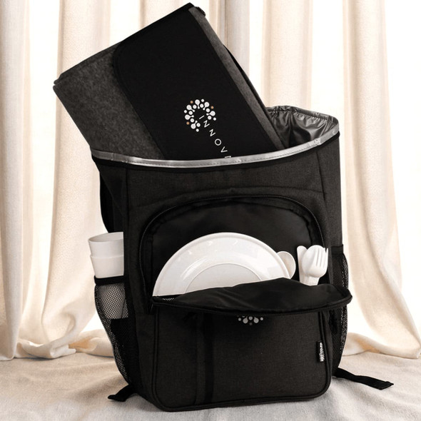 A black picnic backpack with a grey blanket, plates, cutlery, and a drink bottle in external pockets.