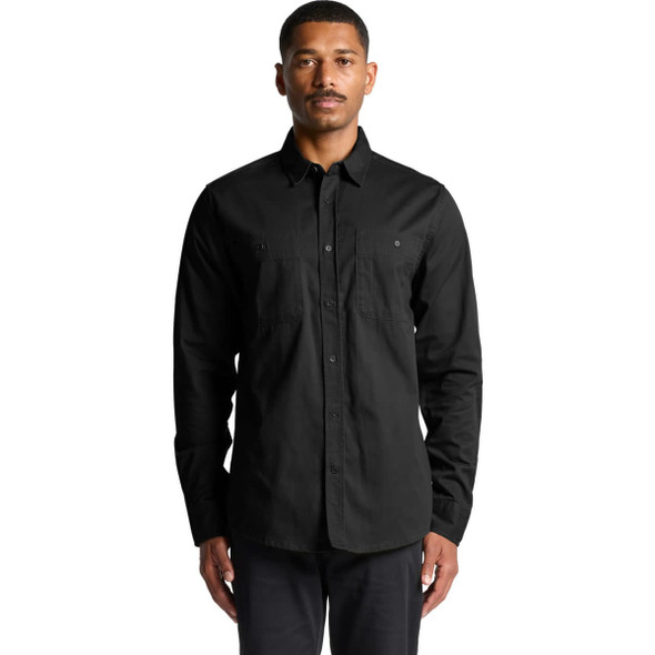 A black work shirt featuring long sleeves and two chest pockets, worn by a model. It includes a logo.