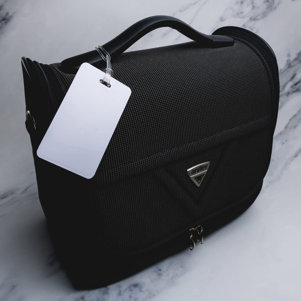 A black luggage tag with a textured surface and a handle, featuring a silver logo and a blank white tag attached.