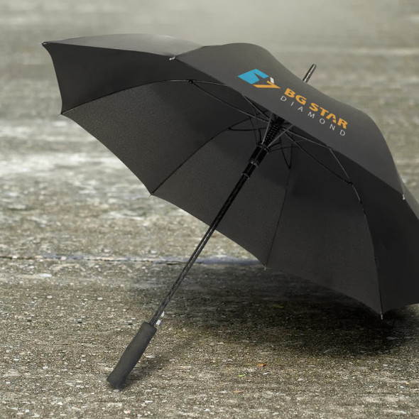 A black umbrella with a curved handle and a logo on its canopy, resting on a wet surface.