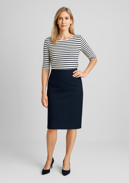A woman stands in a relaxed fit, lined skirt in navy, paired with a striped top and heels. The image features branding.