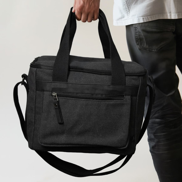 A black canvas cooler bag with dual handles and a shoulder strap, featuring a front zip pocket.