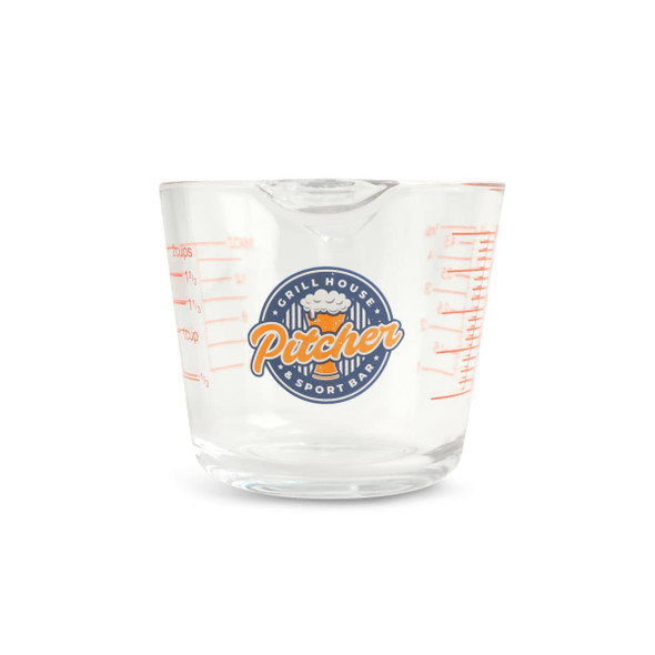 A clear glass measuring jug with red measurement markings and a logo on the front.