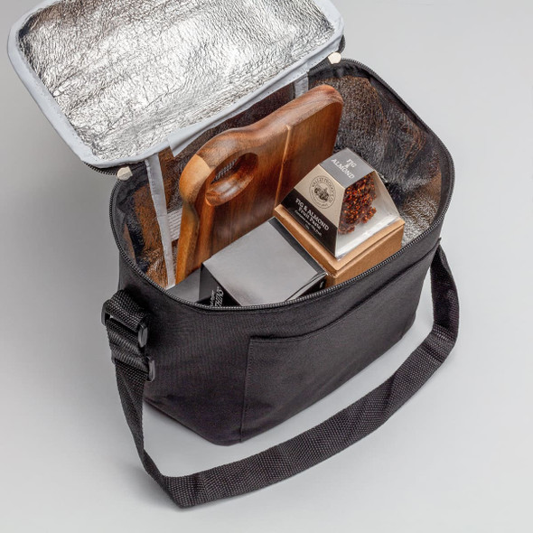A black cooler bag with a silver insulated interior, containing a wooden cutting board and packaged food items.