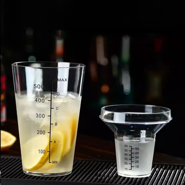 A drink bottle and measuring cup with markings, featuring clear plastic and a spout, alongside sliced lemons.