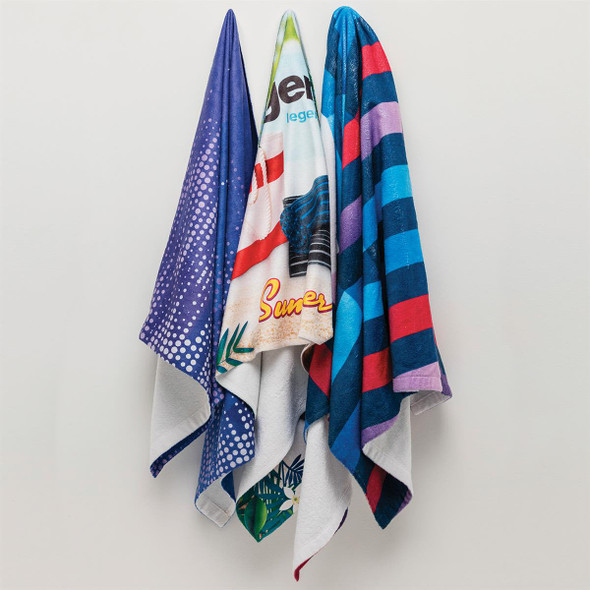 Four custom sublimation beach towels hang together, featuring various patterns and colours including purple, blue, and red stripes.