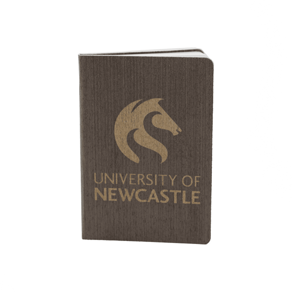 A dark grey eco notebook with a textured cover and a logo on the front. It features gold lettering and branding.