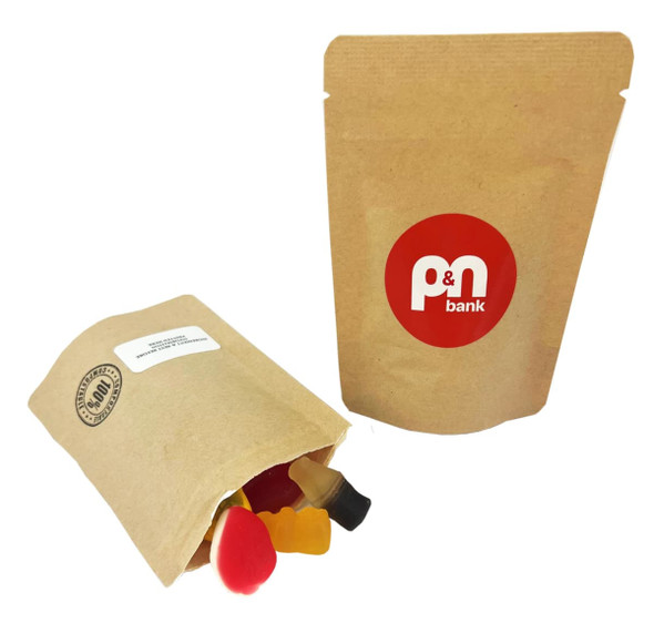 A compostable bag containing assorted mixed lollies in red and yellow, with a logo on the packaging.