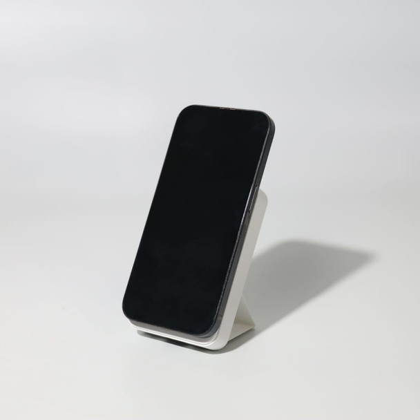 A black wireless charging power bank stands on a white base, showcasing its sleek design.