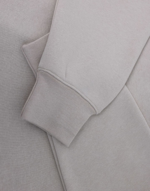 A light grey polar fleece jumper featuring a half zip collar and fitted cuffs. It has a subtle logo.